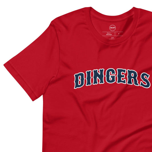 Close up image of red t-shirt with design of "DINGERS" in Boston Red Sox style font located on centre chest. This design is exclusive to Tailgate Mercantile and available only online.